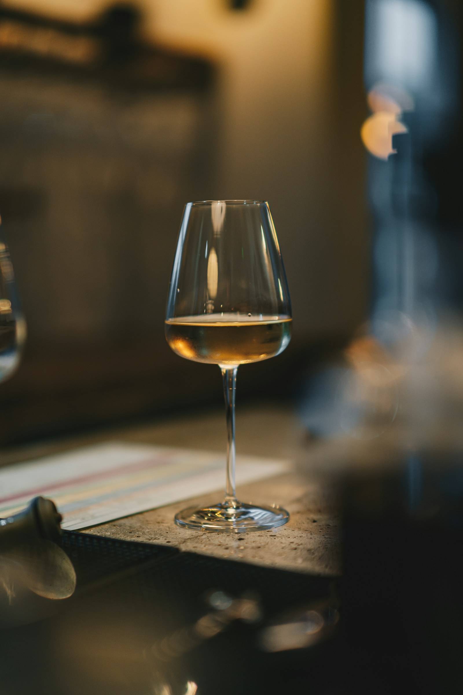 Taça de vinho branco sobre a mesa com luz suave